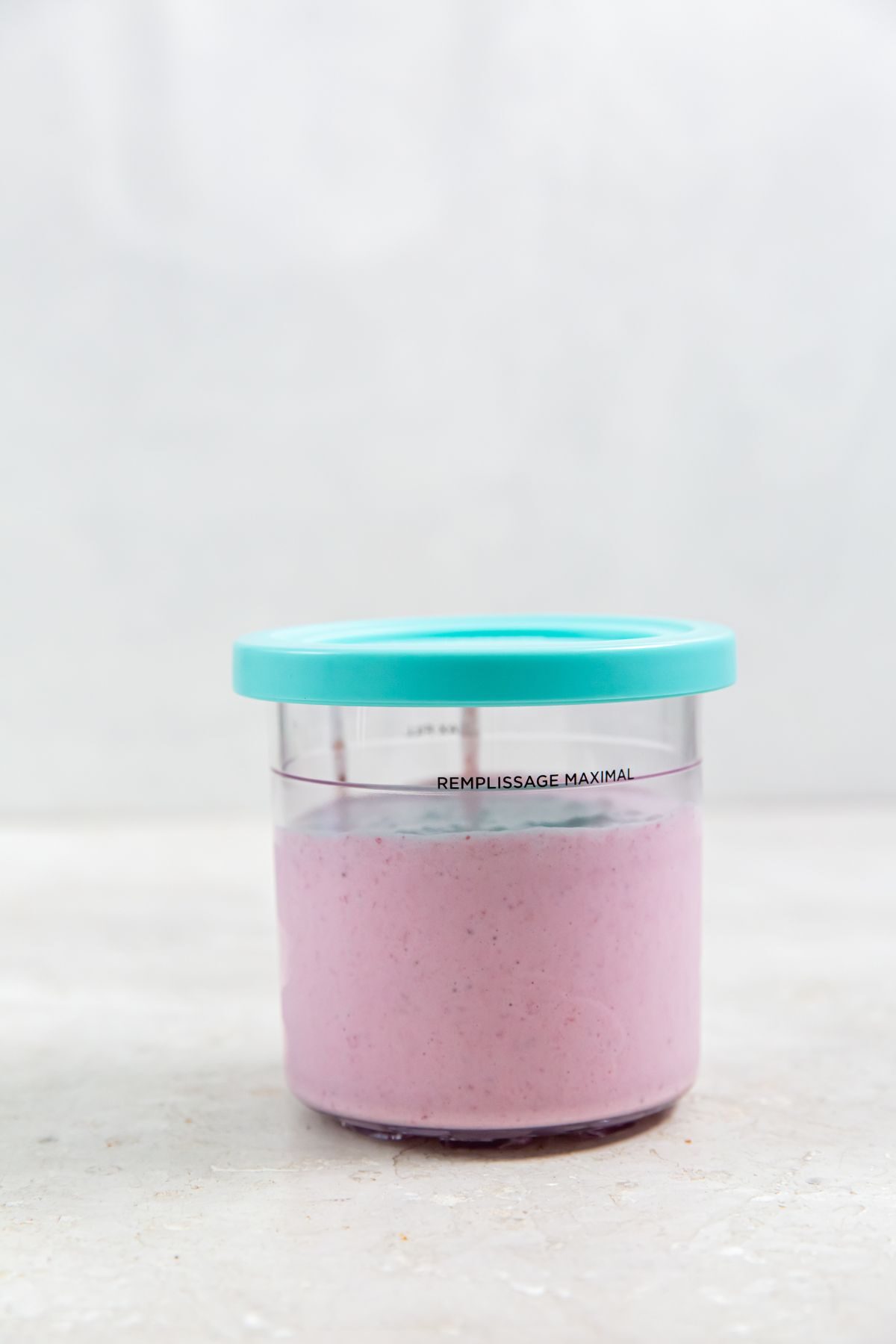 strawberry ice cream base in a plastic Ninja Creami pint container