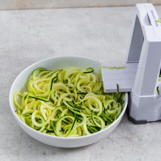 spiralizer with zoodles in a bowl