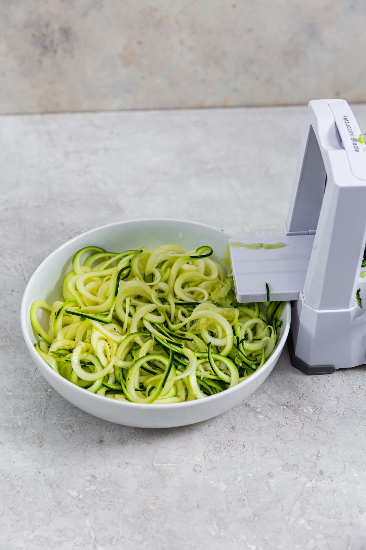 spiralizer with zoodles in a bowl