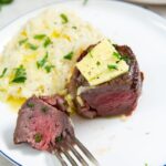 air fryer chuck filets with butter on top with cauliflower mashed on the side with a piece on a fork