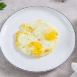 Air Fryer fried eggs on a white plate