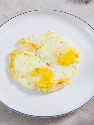 Air Fryer fried eggs on a white plate