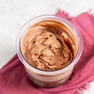 chocolate protein ice cream in pint container on a pink napkin