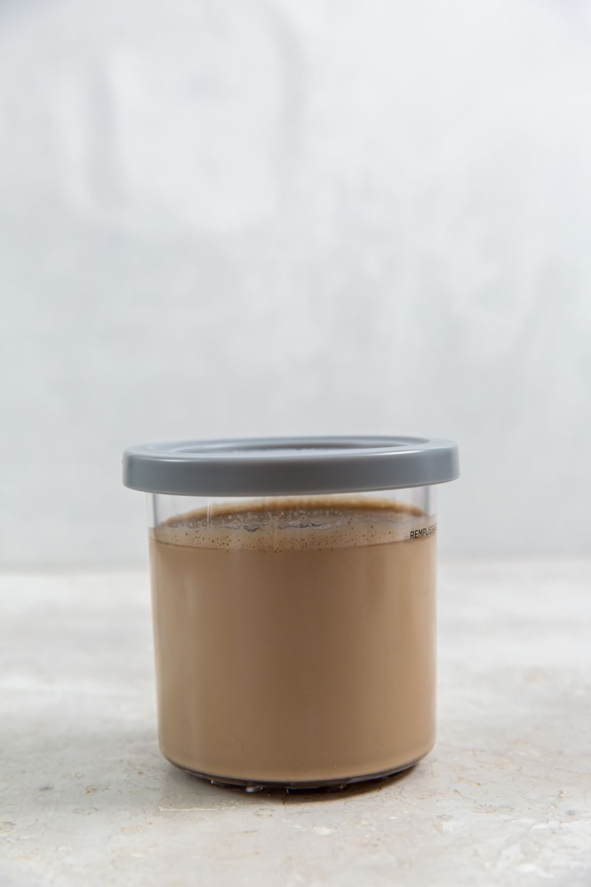 coffee ice cream in a pint container with blue lid