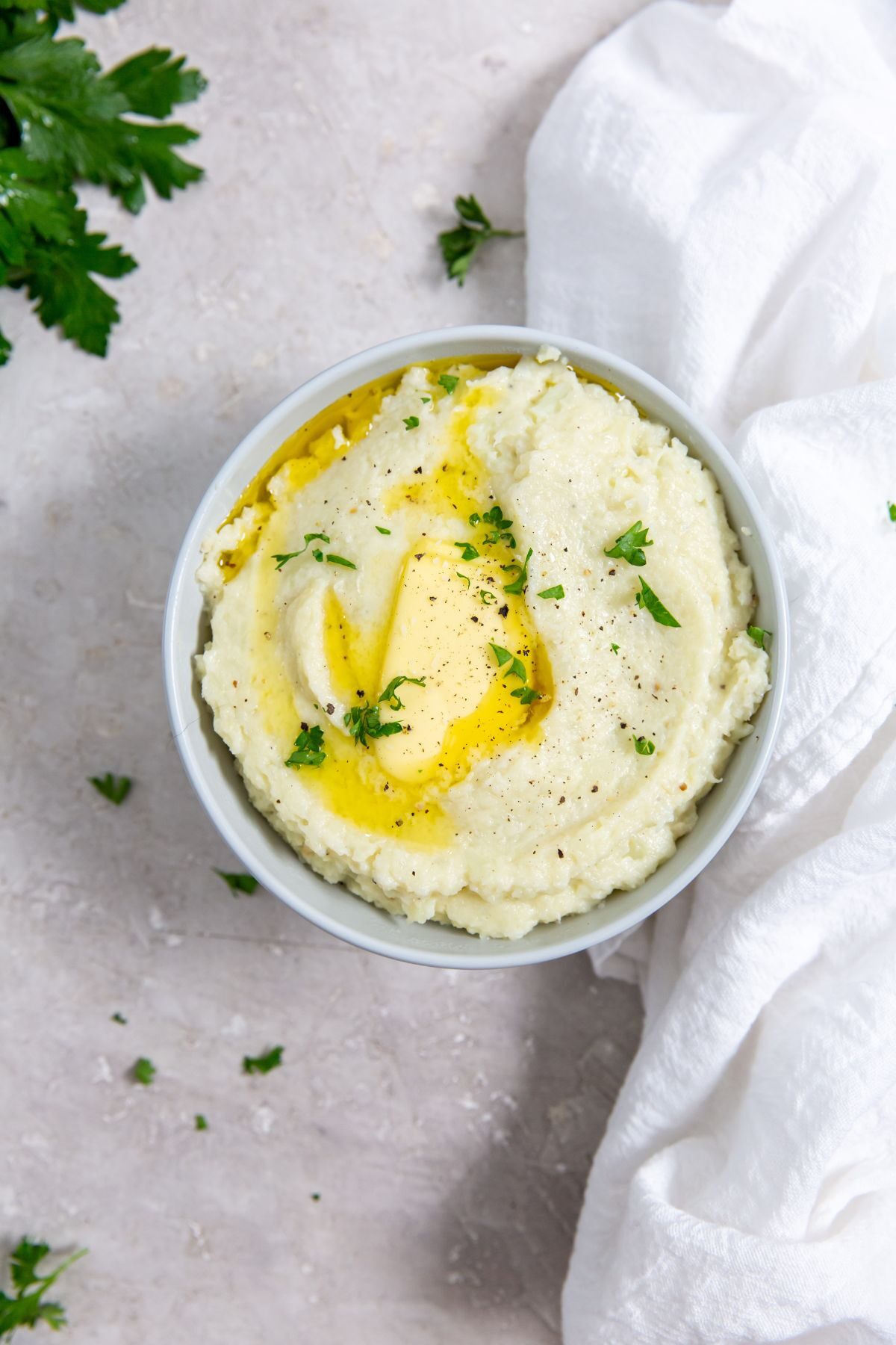 Instant Pot Cheesy Mashed Potatoes in a white bowl with a white napkin on the side