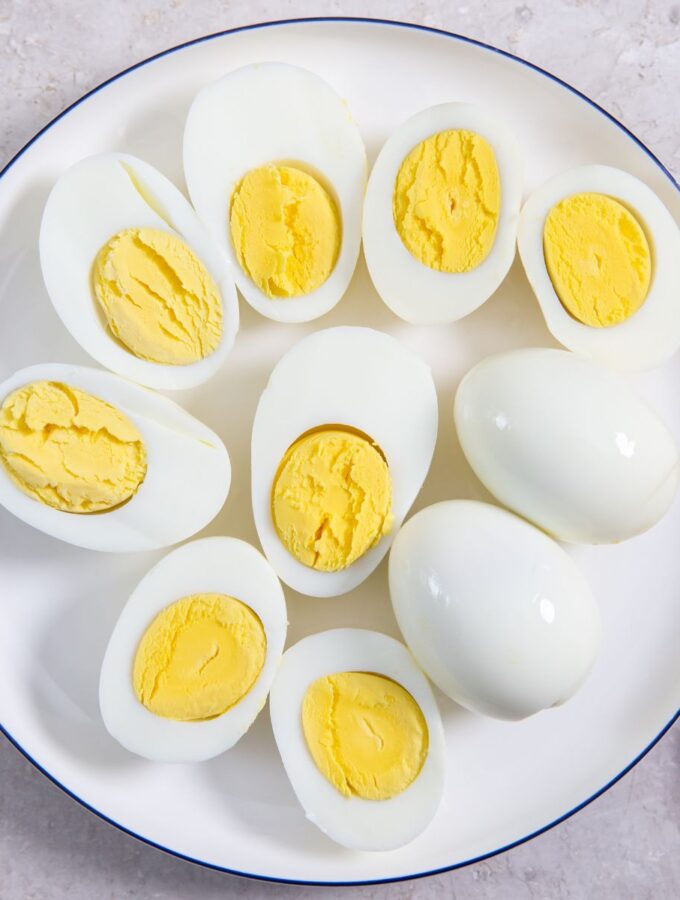 hard boiled eggs sliced in half on a white plate.