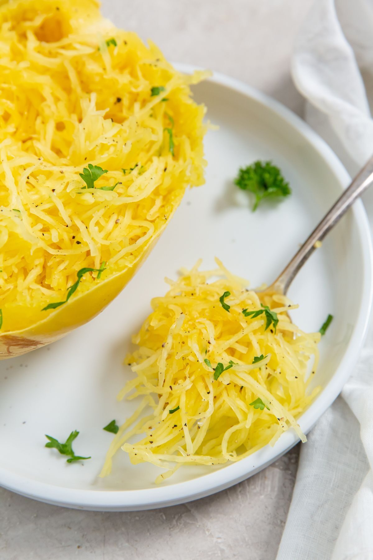 Instant Pot Spaghetti Squash on a white plate with a bite size on it