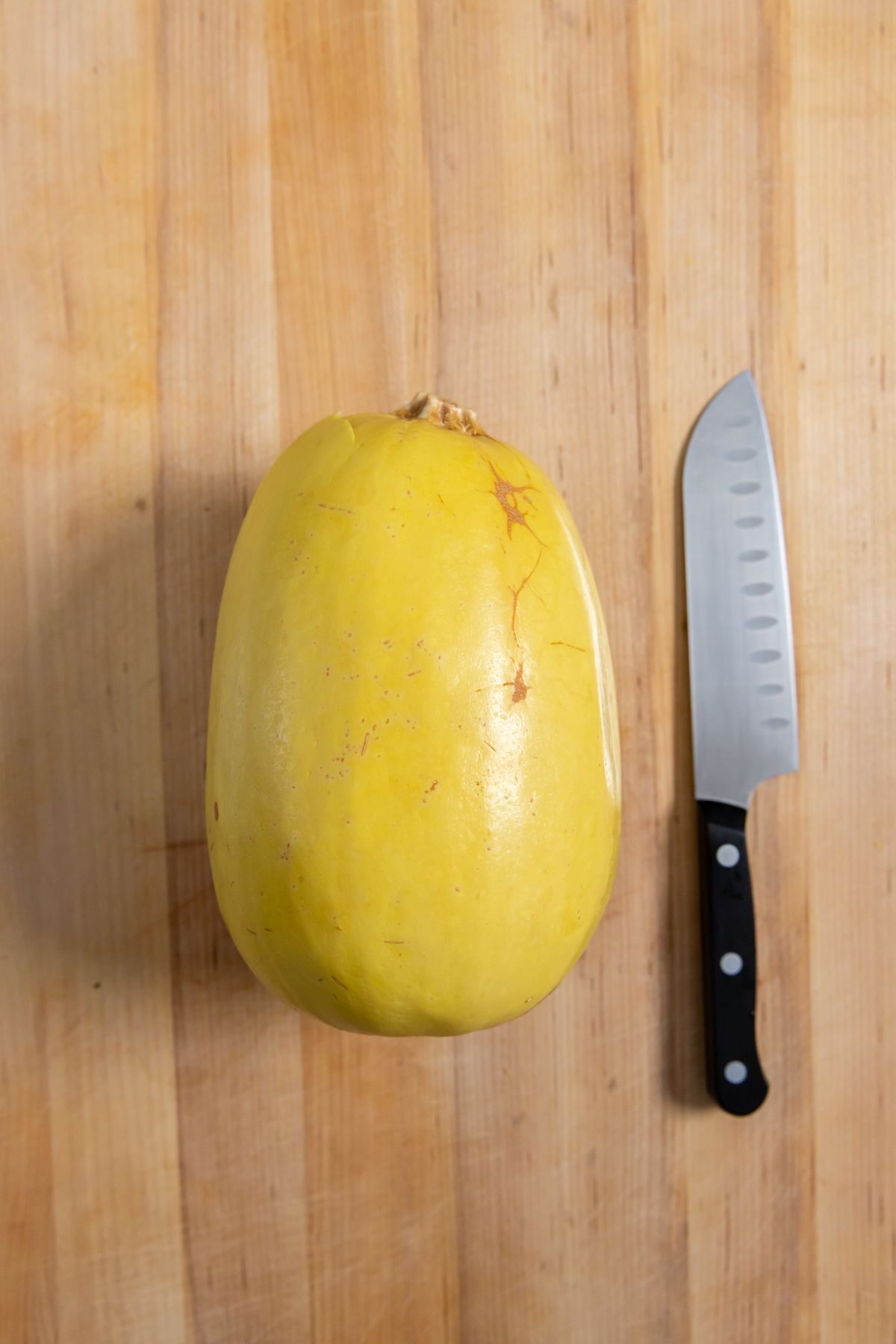 Instant Pot Spaghetti Squash on a cutting board with a knife