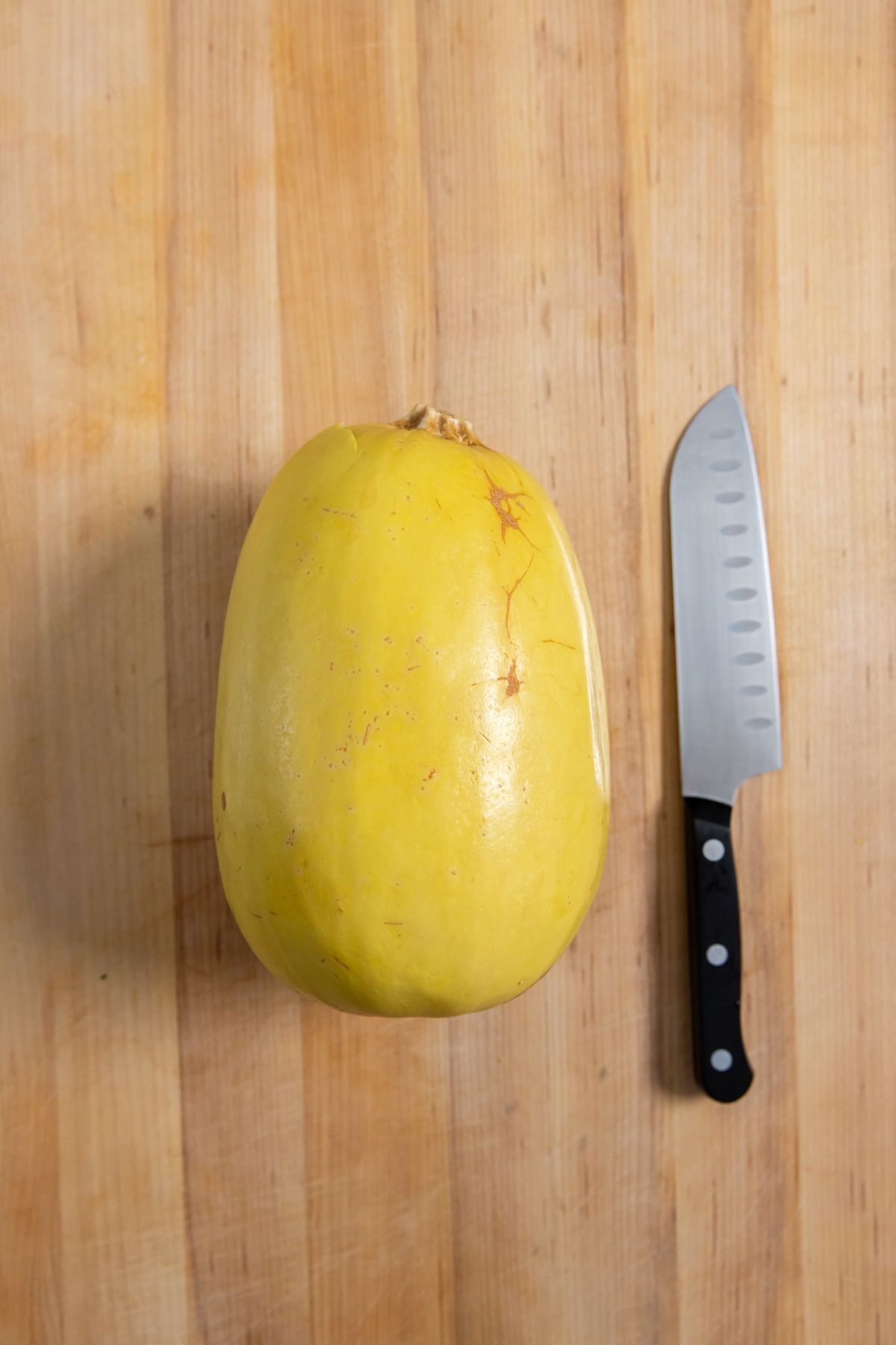 Instant Pot Spaghetti Squash on a cutting board with a knife