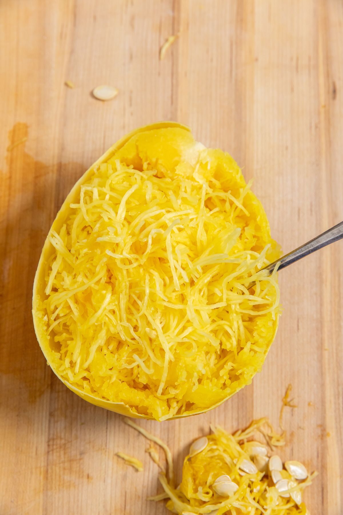 Instant Pot Spaghetti Squash on a cutting board with a spoon in it