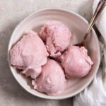 low carb strawberry ice cream in a white bowl with a spoon