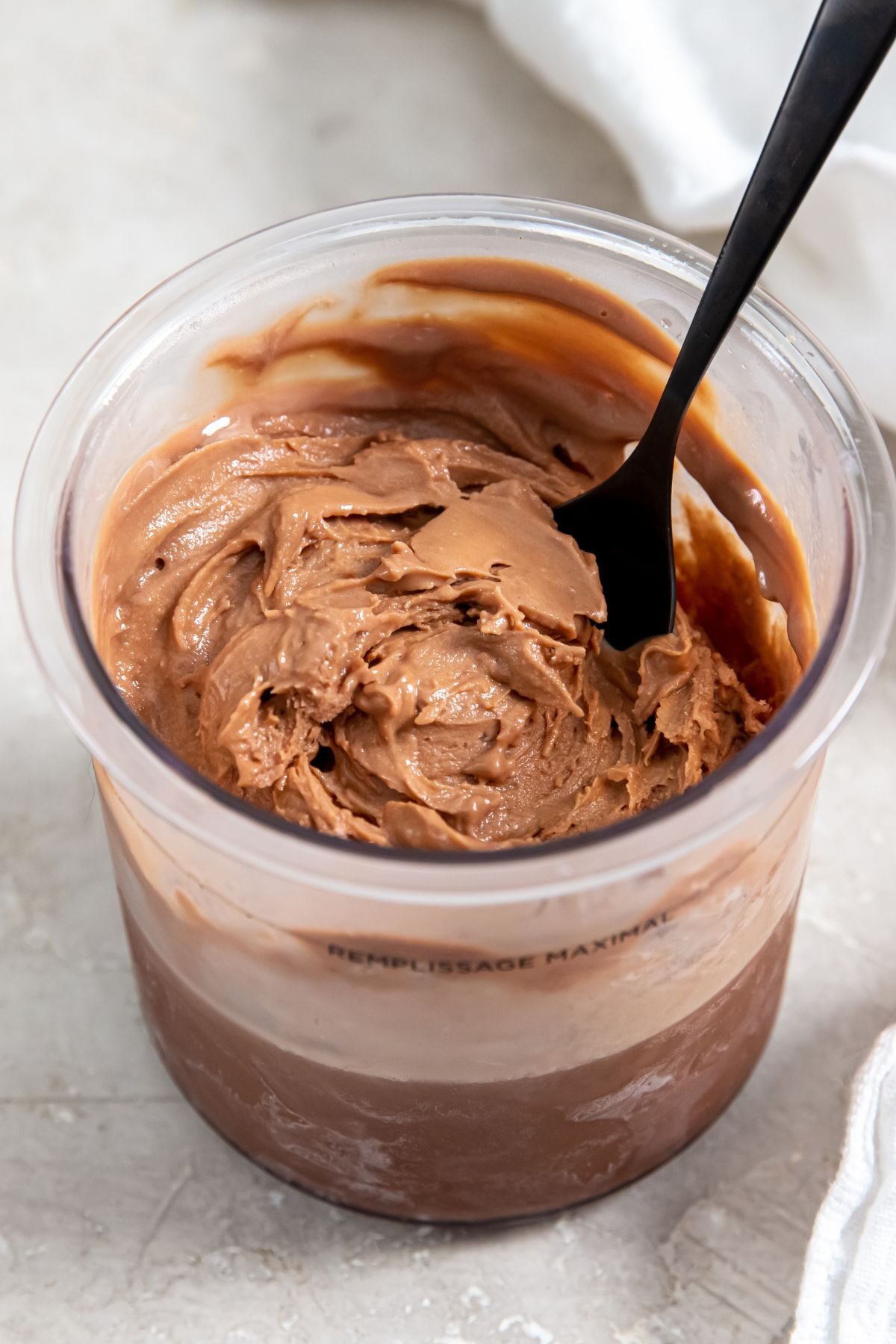 Chocolate protein ice cream without bananas in a clear pint with a black spoon