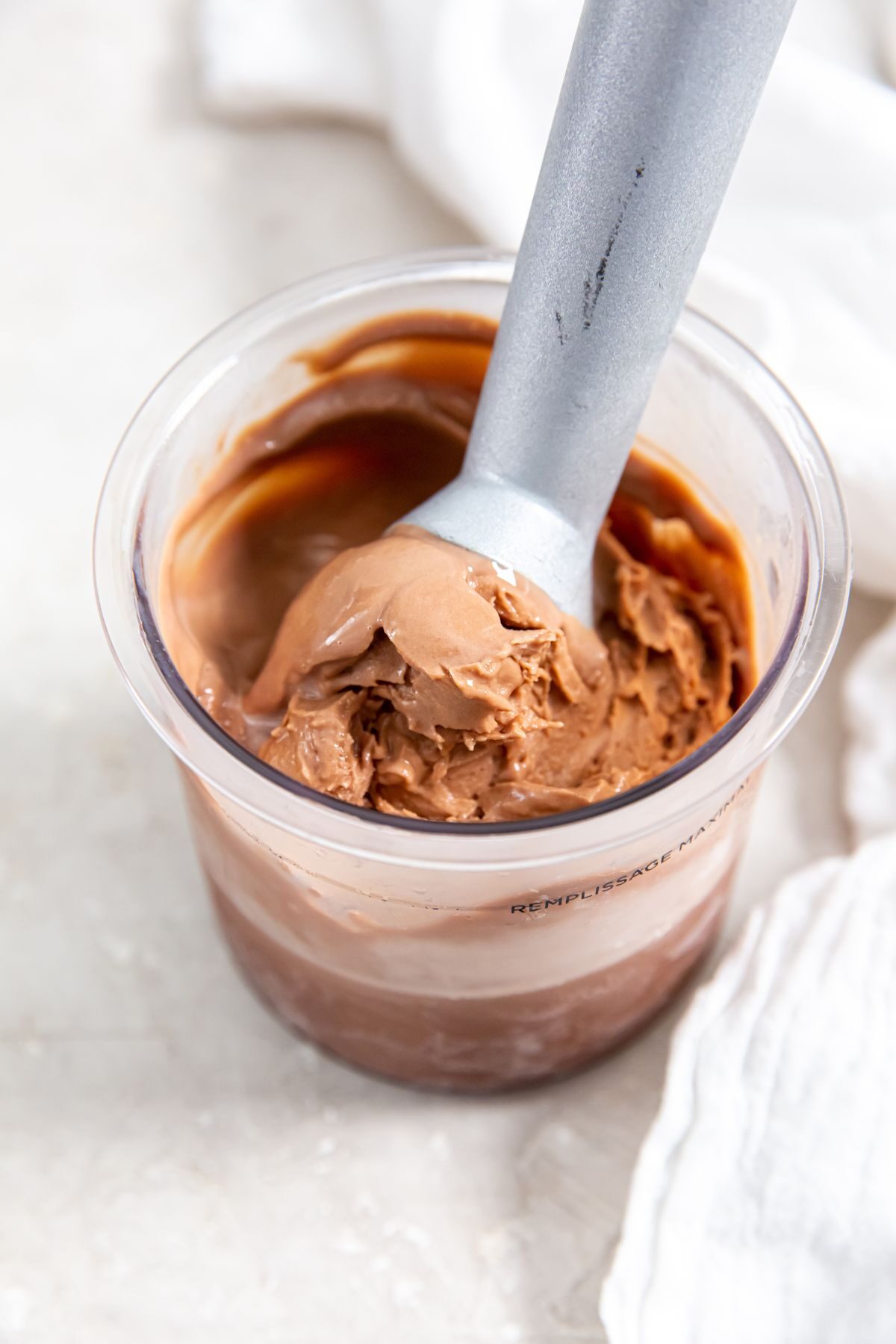chocolate protein ice cream in pint container with scoop
