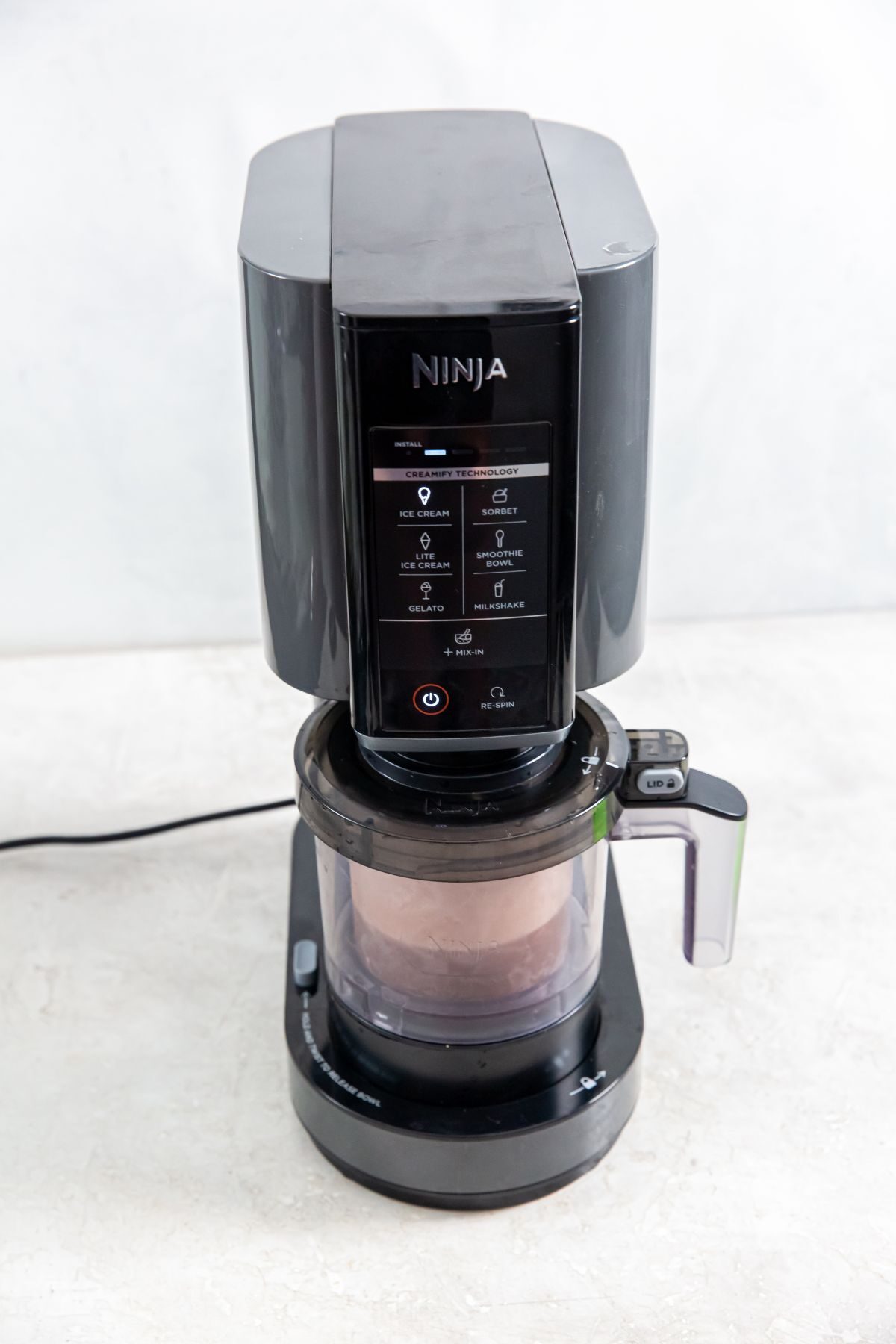 Ninja Creami with chocolate protein ice cream ingredients in pint cup