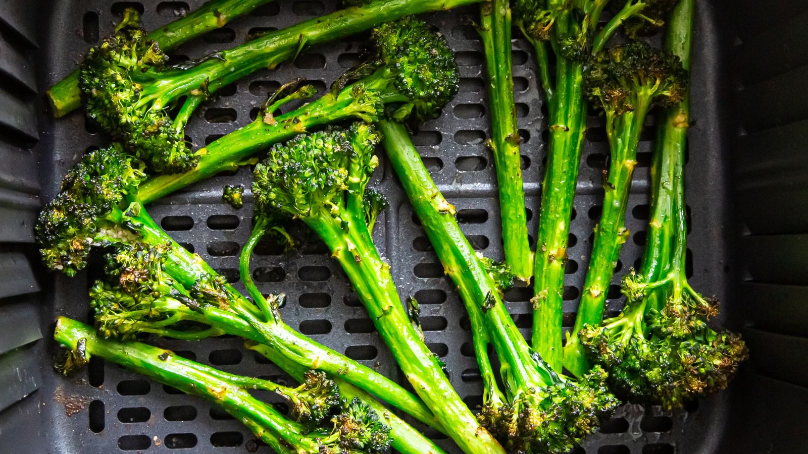 air fryer broccolini in an air fryer basket.
