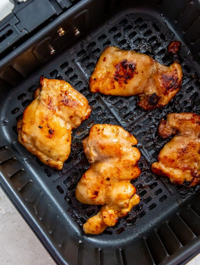 cooked paleo chicken thighs in an air fryer basket