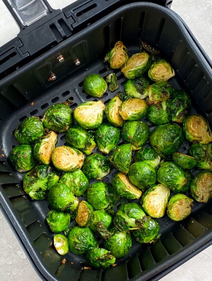 cooked brussel sprouts in an air fryer basket