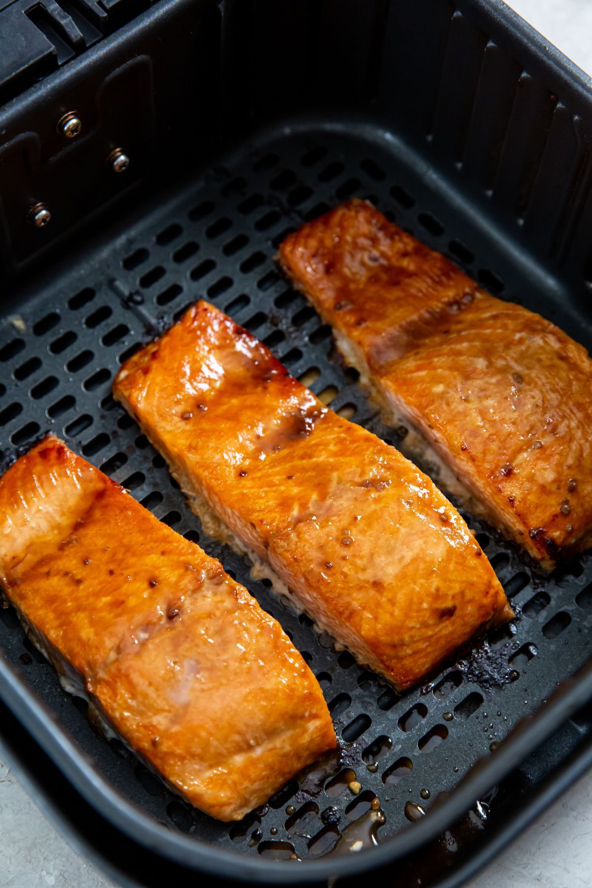 Air Fryer frozen salmon with teriyaki sauce in the air fryer basket