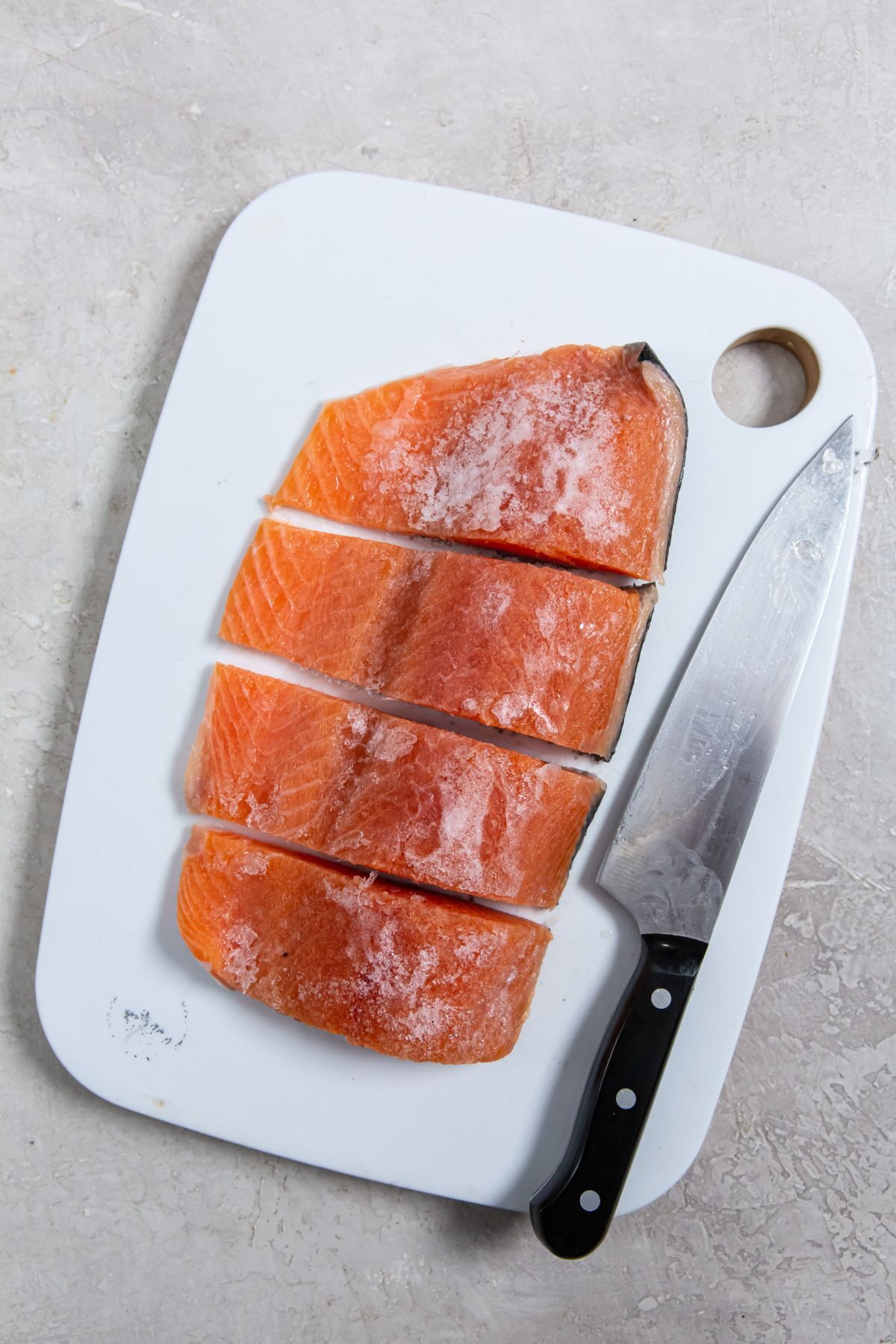 Air Fryer Frozen Salmon on a cutting board with a knife