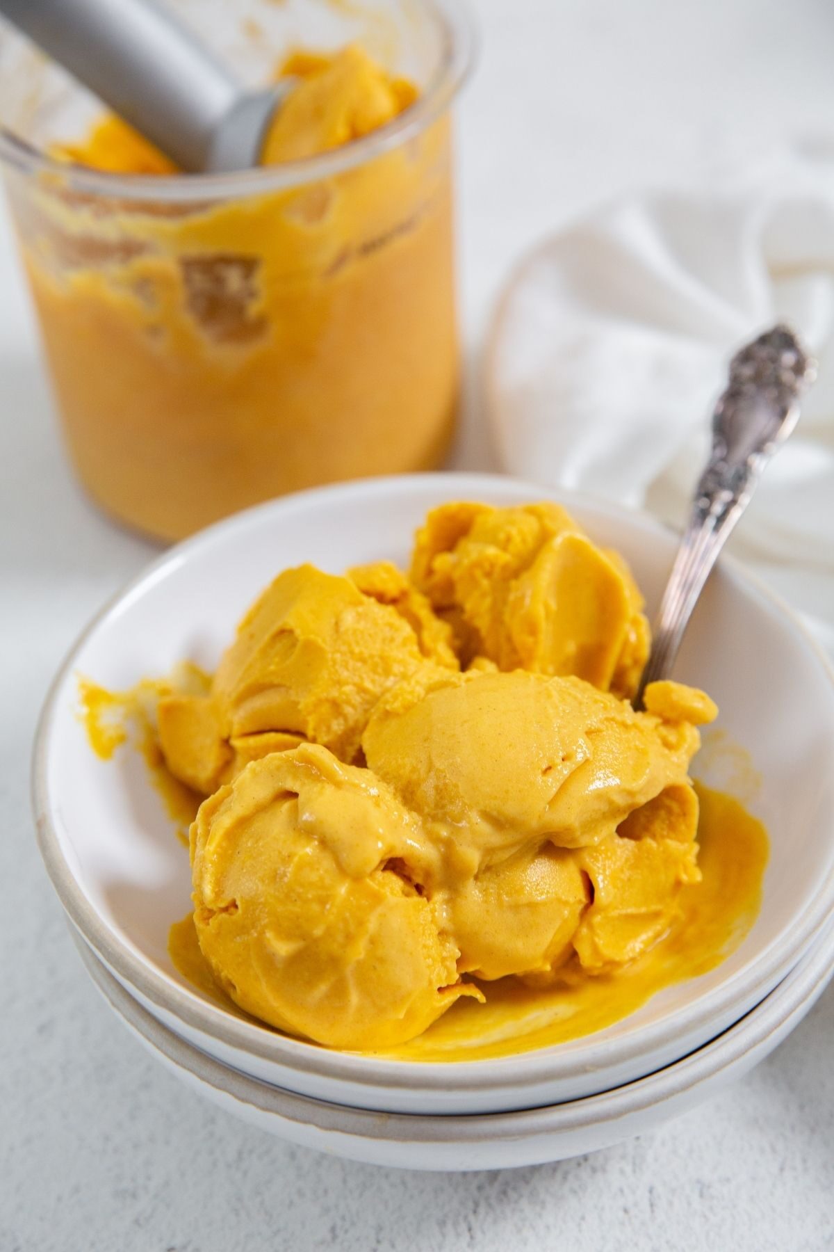 Ninja Creami Pumpkin Ice Cream in a bowl with a spoon in it and a white napkin on the side