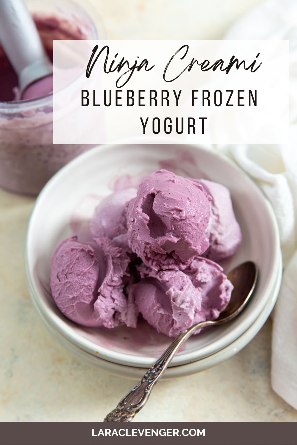 pin of ninja creami low carb blueberry frozen yogurt in a bowl with a spoon and white napkin