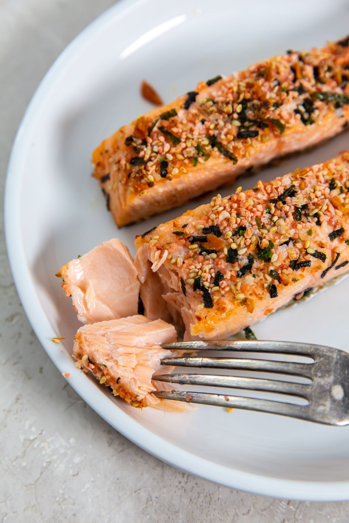 Air Fryer Furikake Salmon on a white plate with a fork in a piece