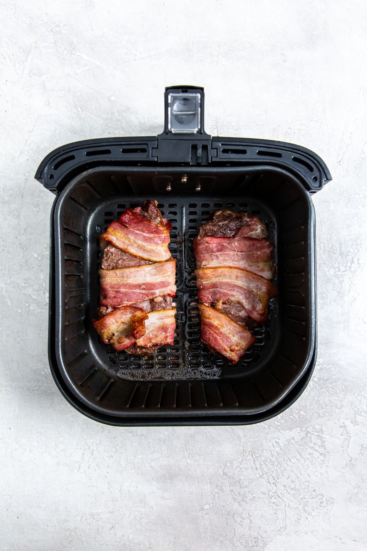 Bacon Wrapped Ribeye Steak in the air fryer basket