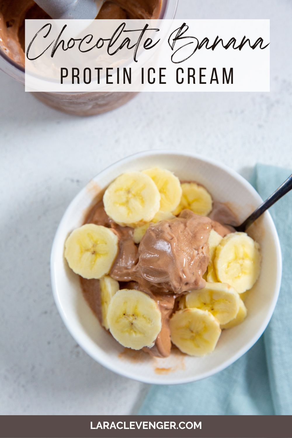 pin of Chocolate Banana Protein Ice Cream in a white bowl with banana slices on top and a spoon in it with a blue napkin next to it