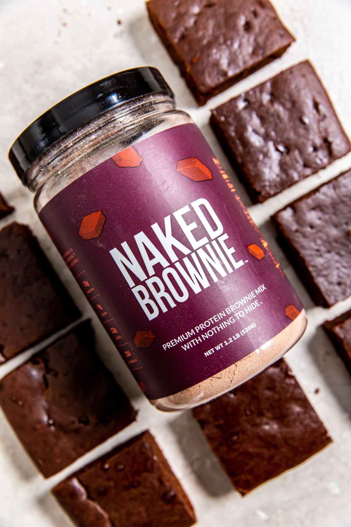 a container of naked protein surrounded by baked protein brownies.