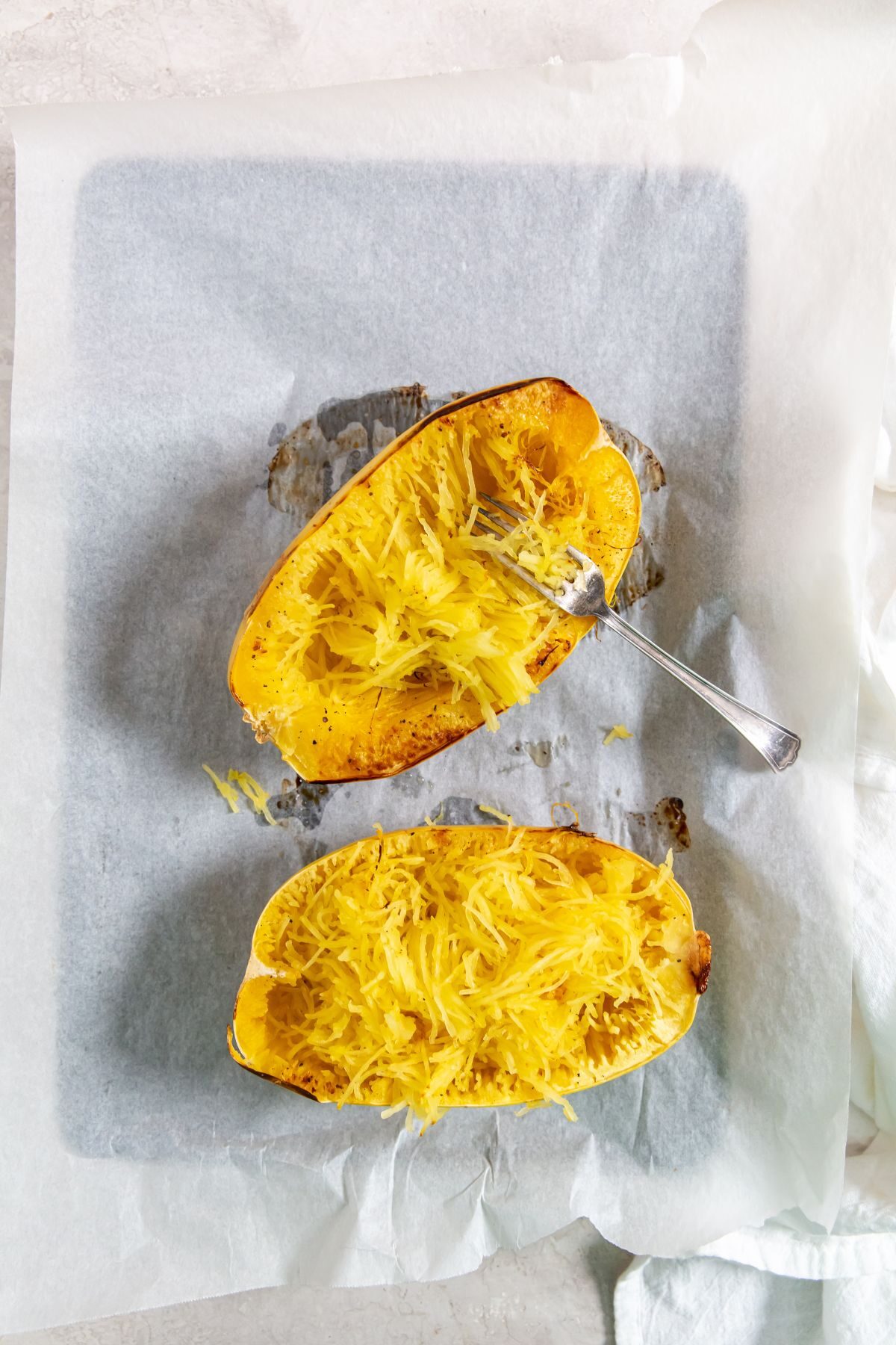Roasted Spaghetti Squash with a fork in it on a baking sheet
