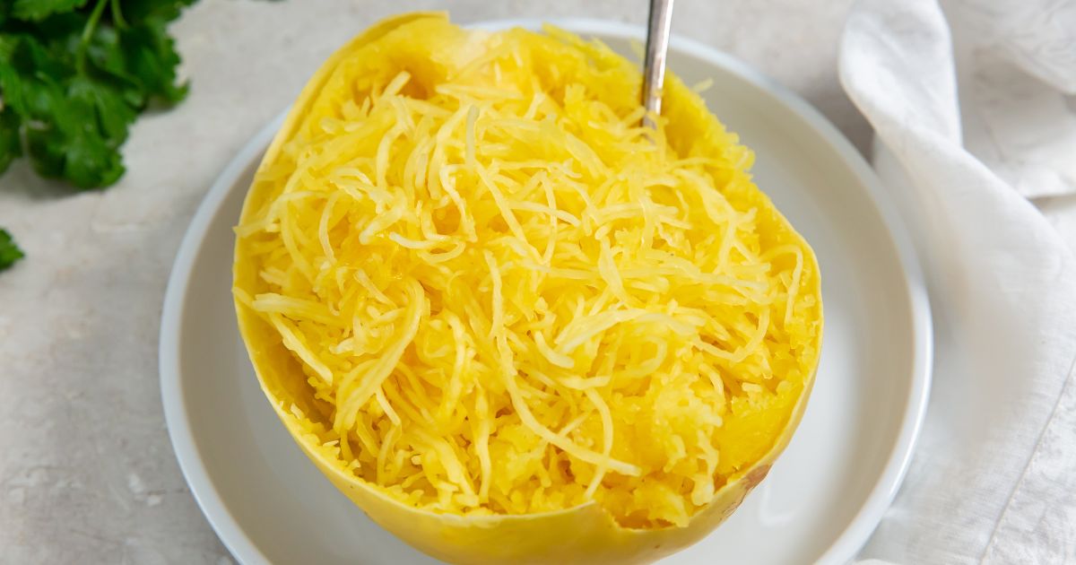 cooked whole spaghetti squash cut in half on a white plate