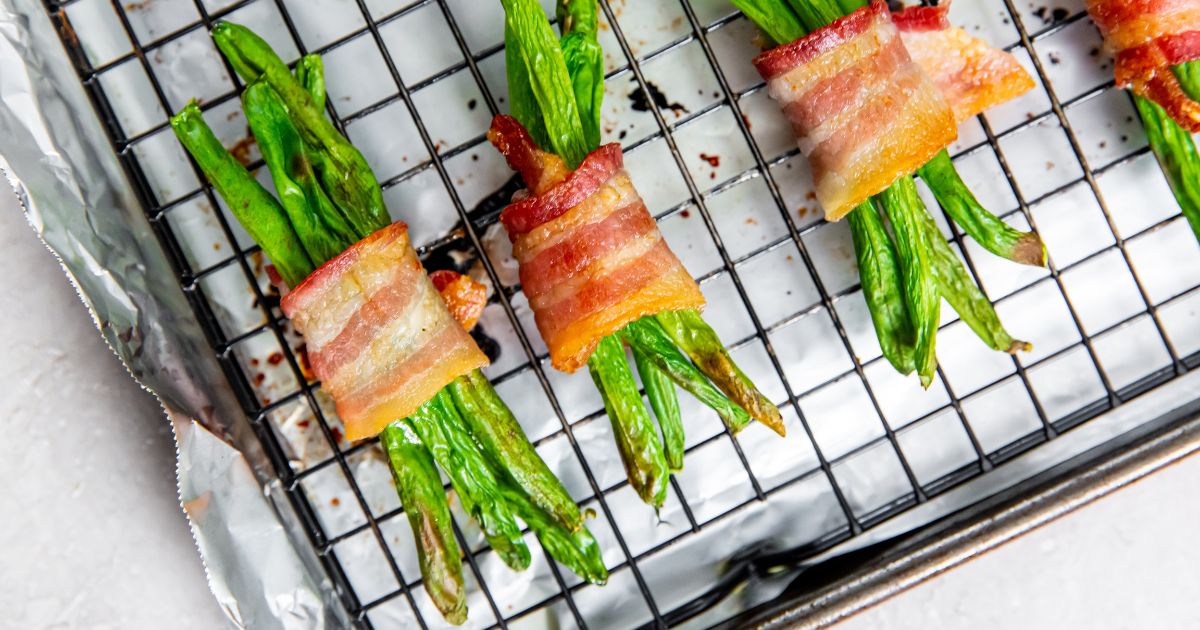 bacon wrapped green beans on a baking sheet