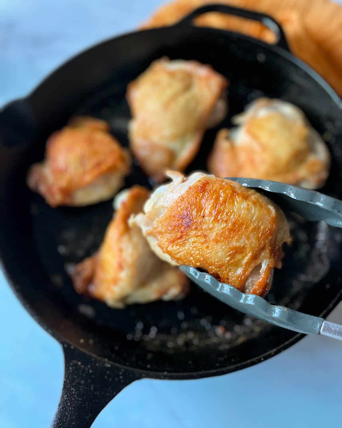 chicken thighs cooked in a cast iron skillet