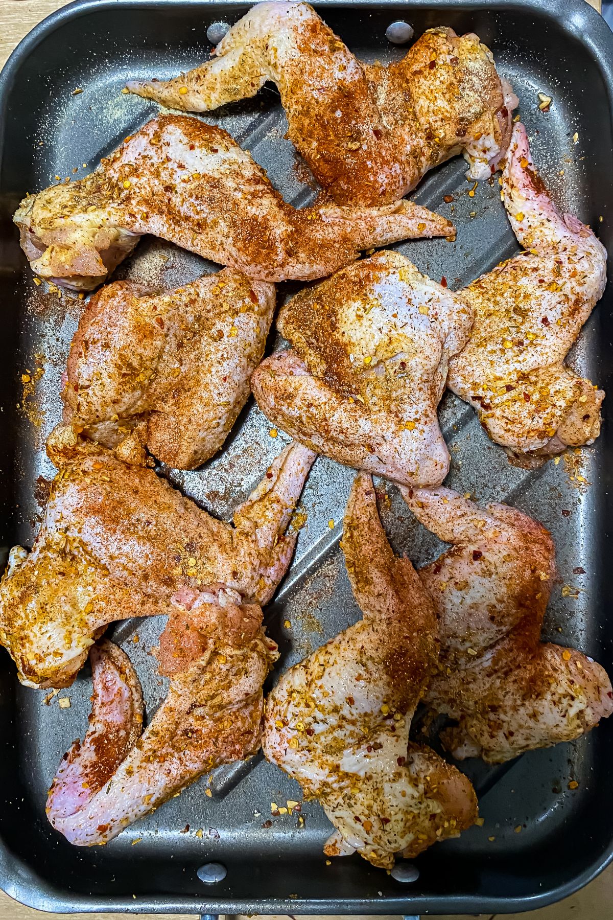 raw seasoned chicken wings on a baking sheet