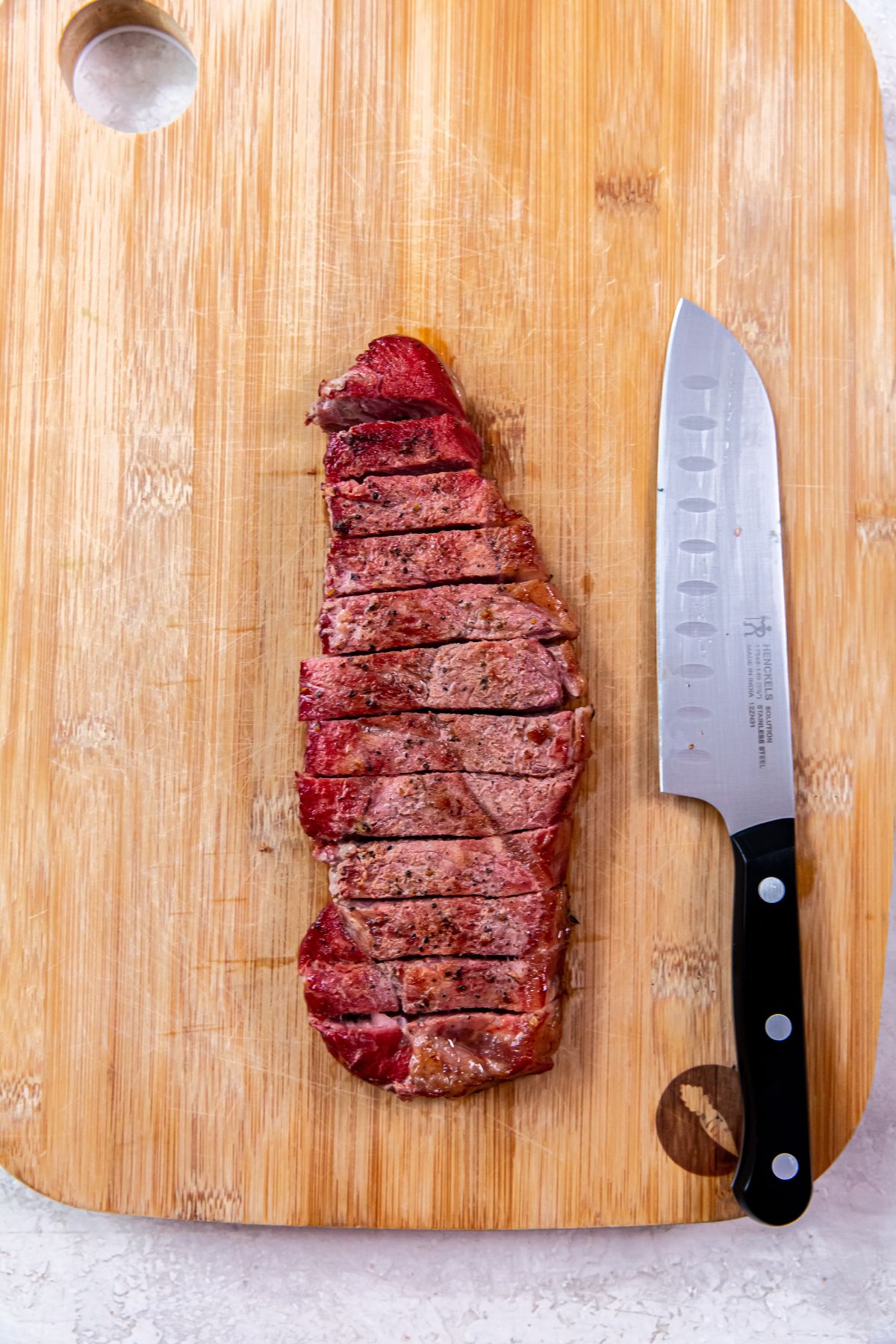Smoked New York Strip Steaks on a cutting board with a knife