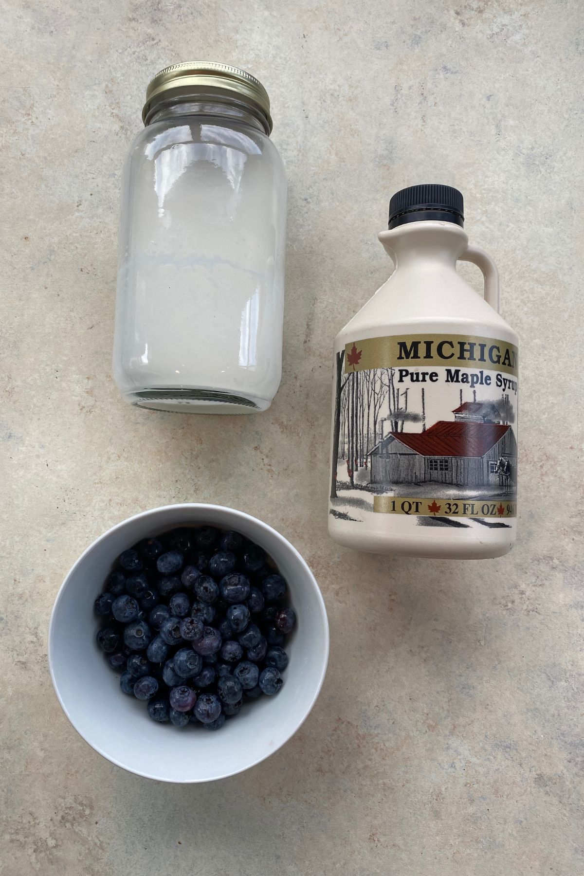 A jar of blueberries and a jar of milk combined to create a delicious blueberry ice cream.
