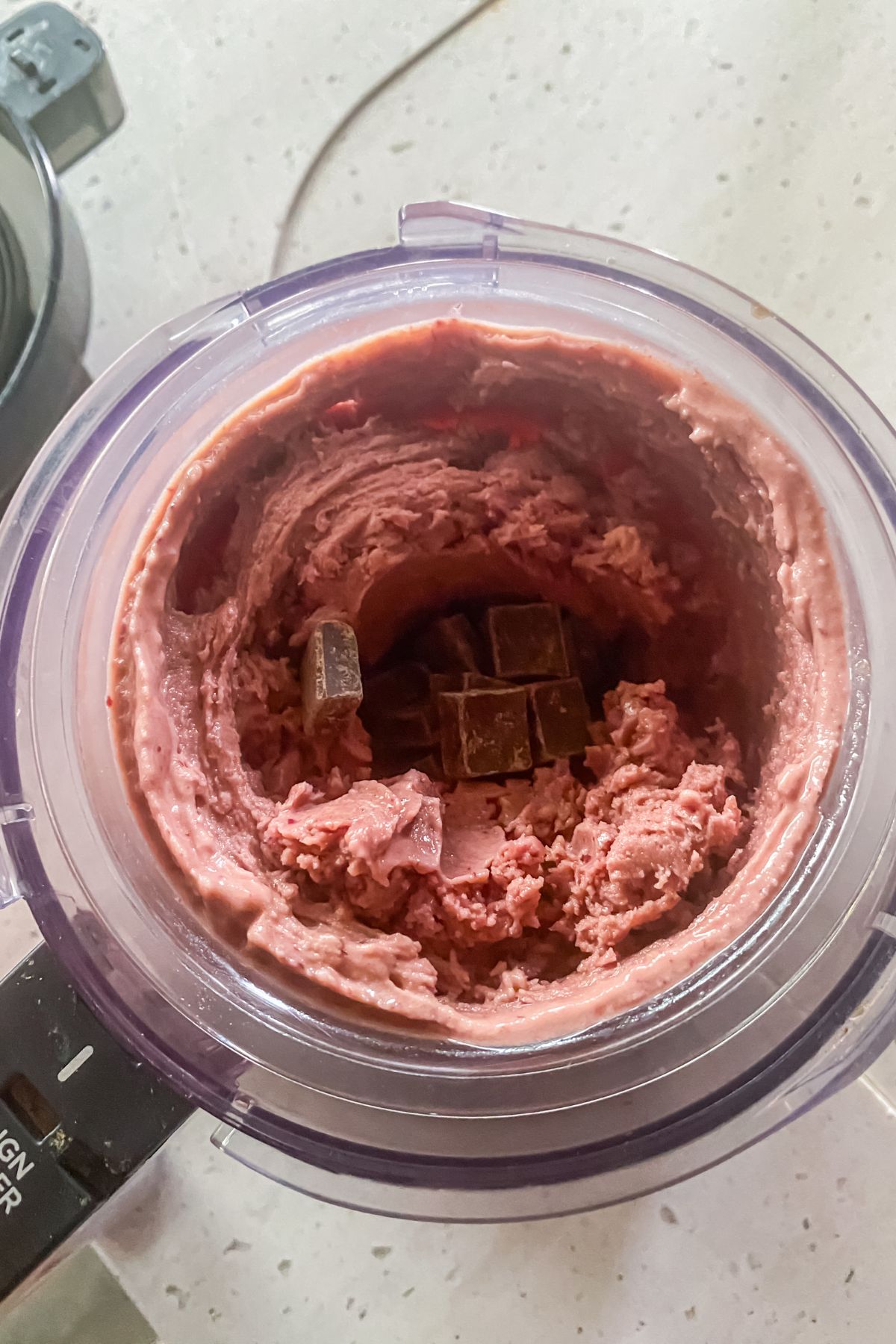 A blender filled with a mixture of chocolate and raspberry-cherry ice cream.