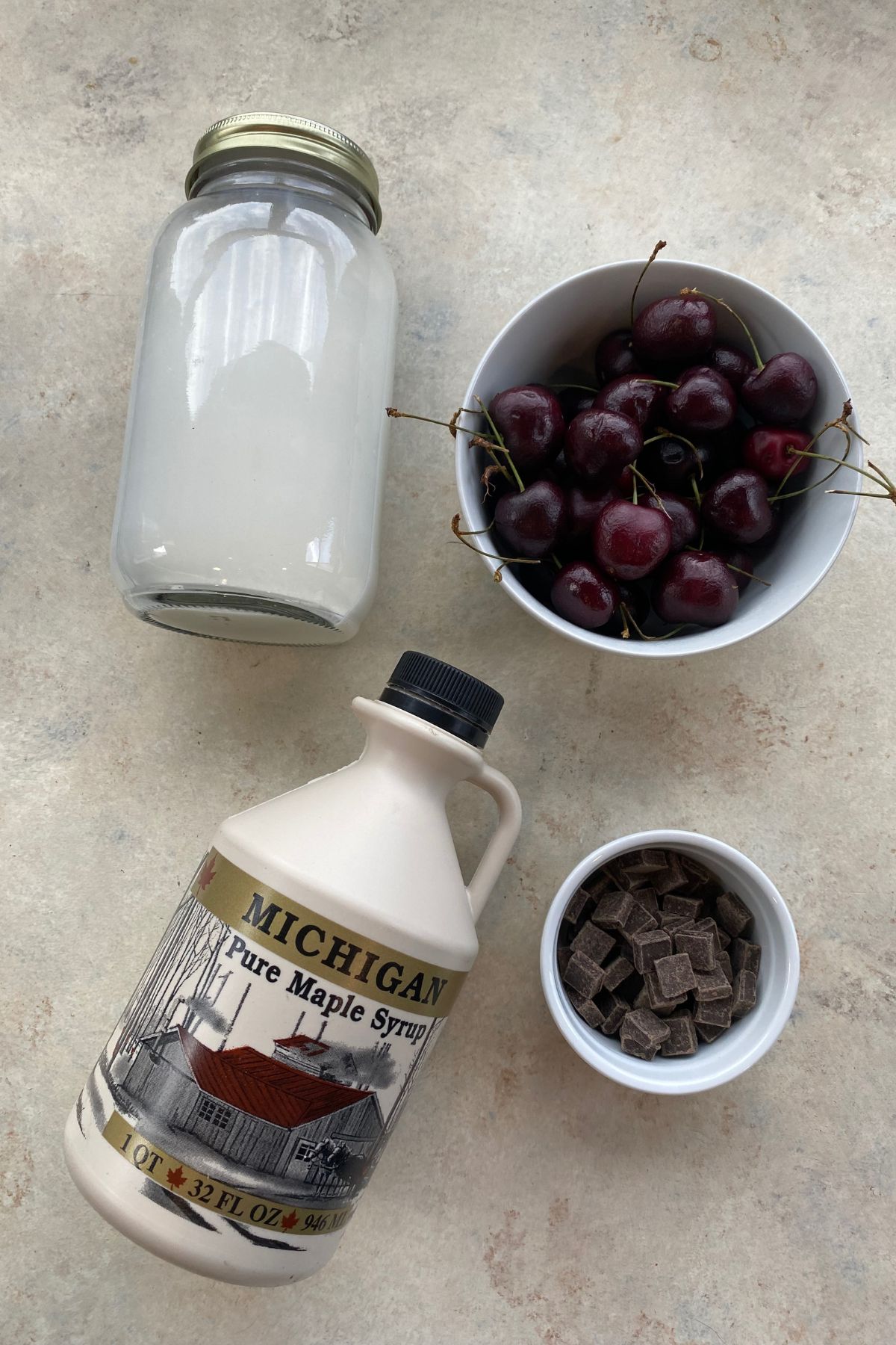 A jar of chocolate syrup, cherries and chocolate chips, perfect for indulging in cherry chocolate chip ice cream.