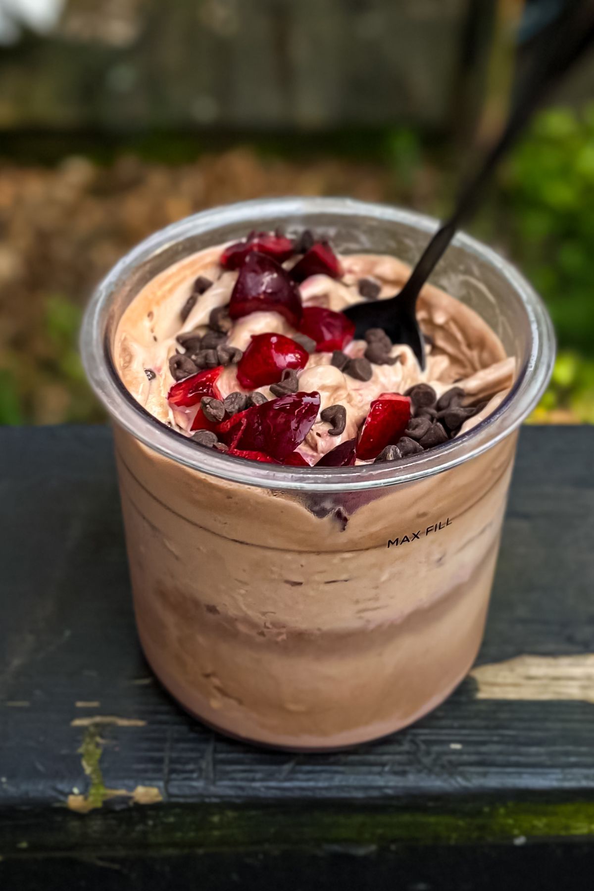 A chocolate ice cream bowl topped with cherries.