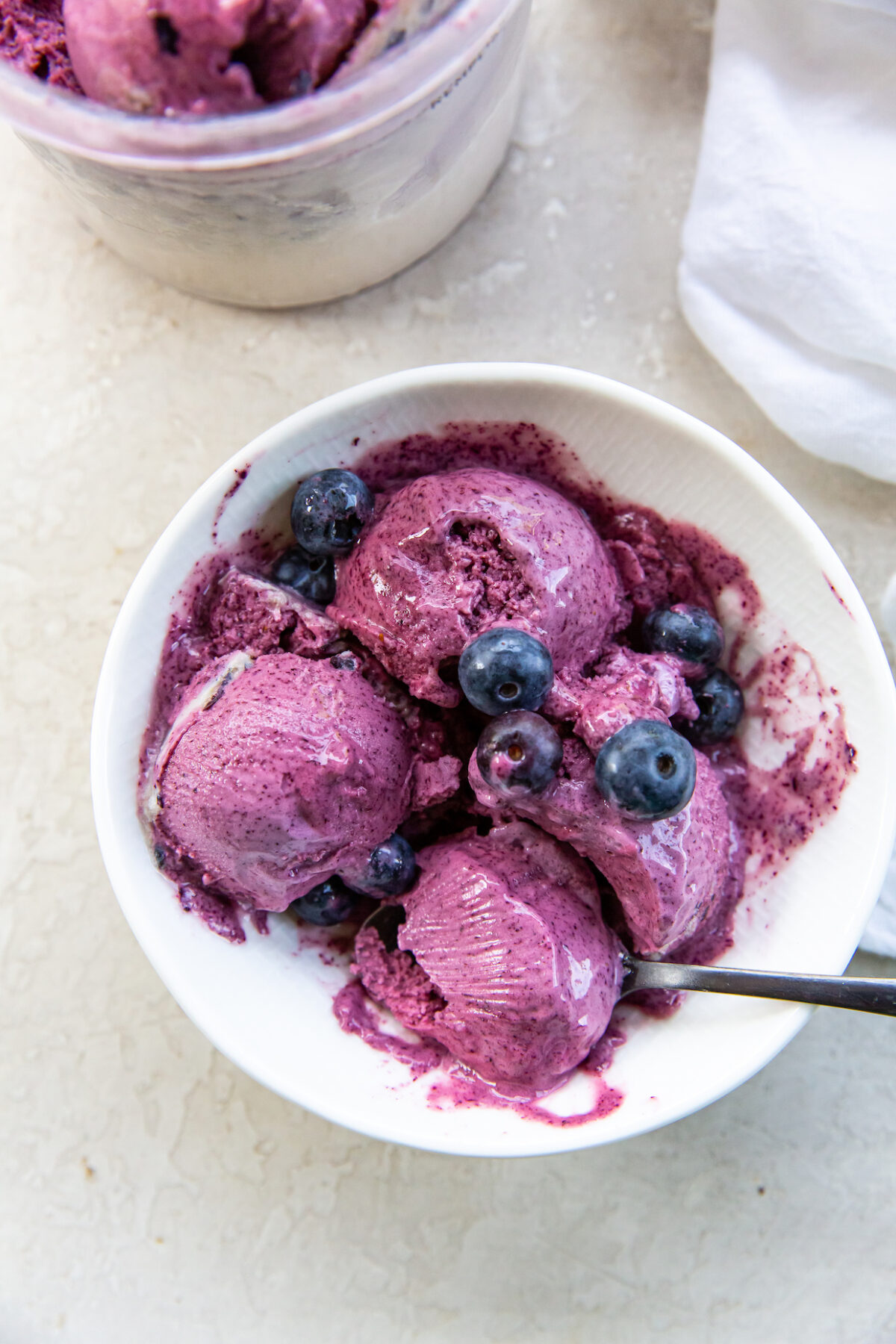 Ninja Creami Blueberry ice cream in a Bowl with a Spoon topped with blueberries