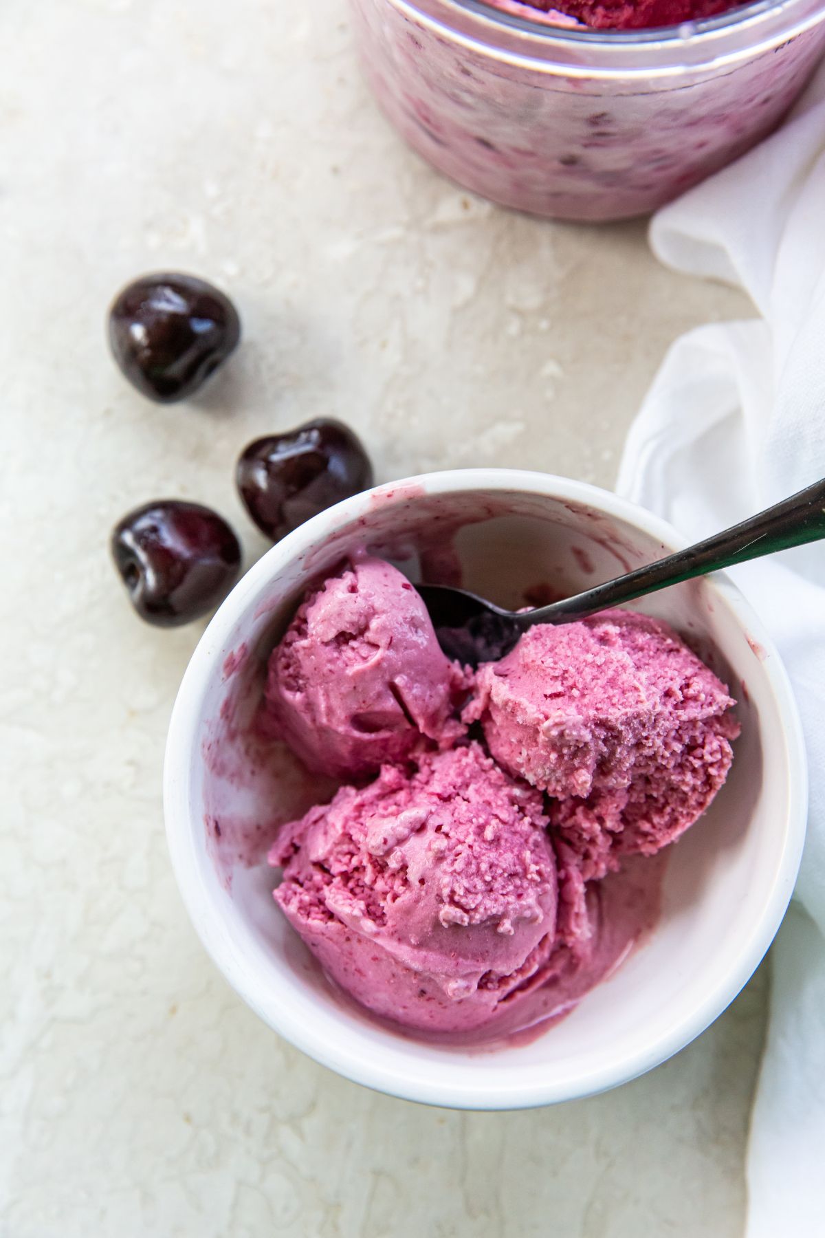 Cherry ice cream in a bowl with cherries.