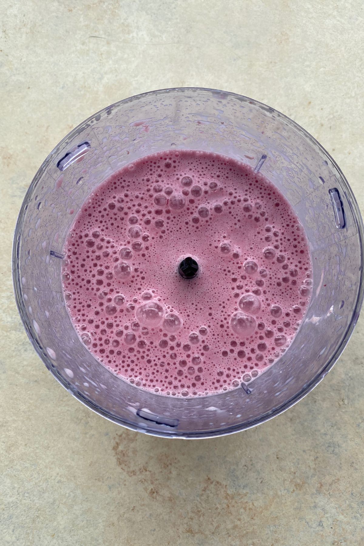 A blueberry smoothie in a bowl on a table.