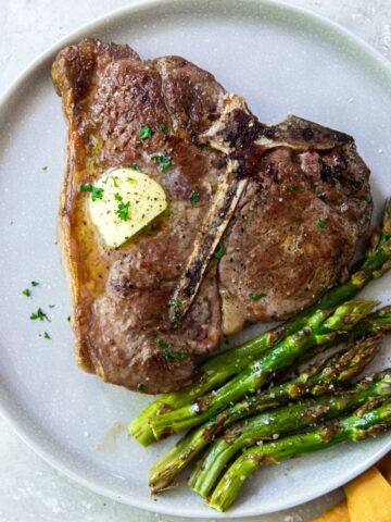 A plate with steak and asparagus on it.