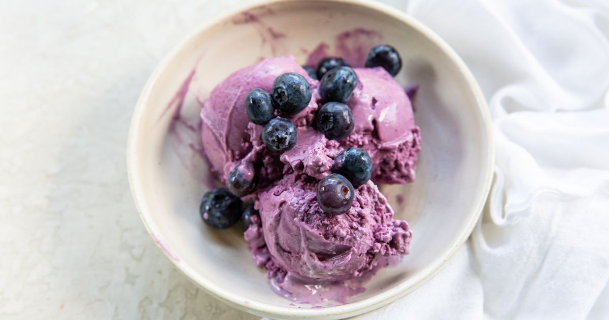 Blueberry Cheesecake ice cream topped with blueberries in a bowl.