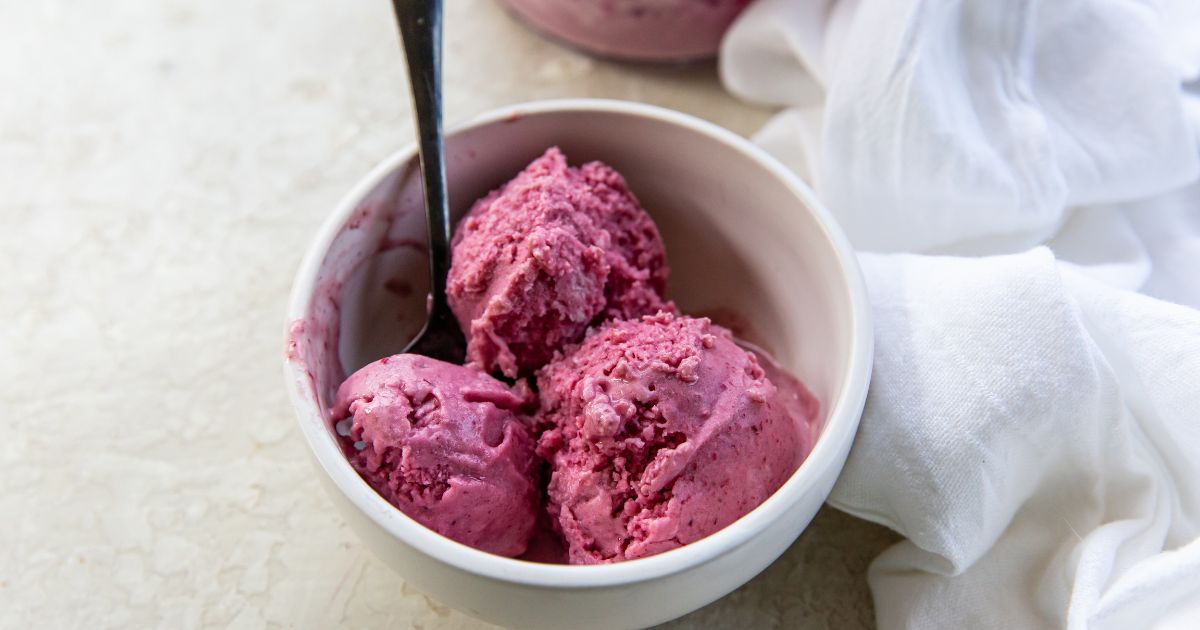A bowl of pink ice cream with a spoon.