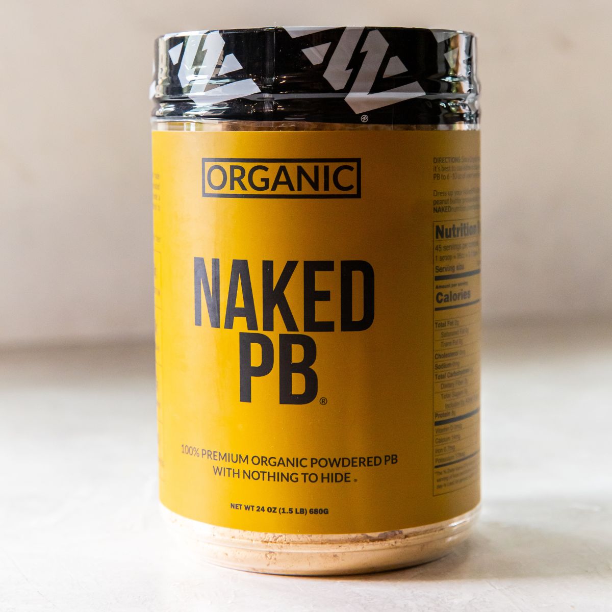 A jar of naked pb on a table.