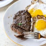 A plate with burgers and eggs on it.