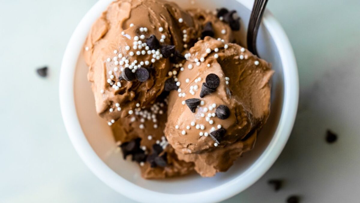 chocolate ice cream with chocolate chips and sprinkles and a spoon.
