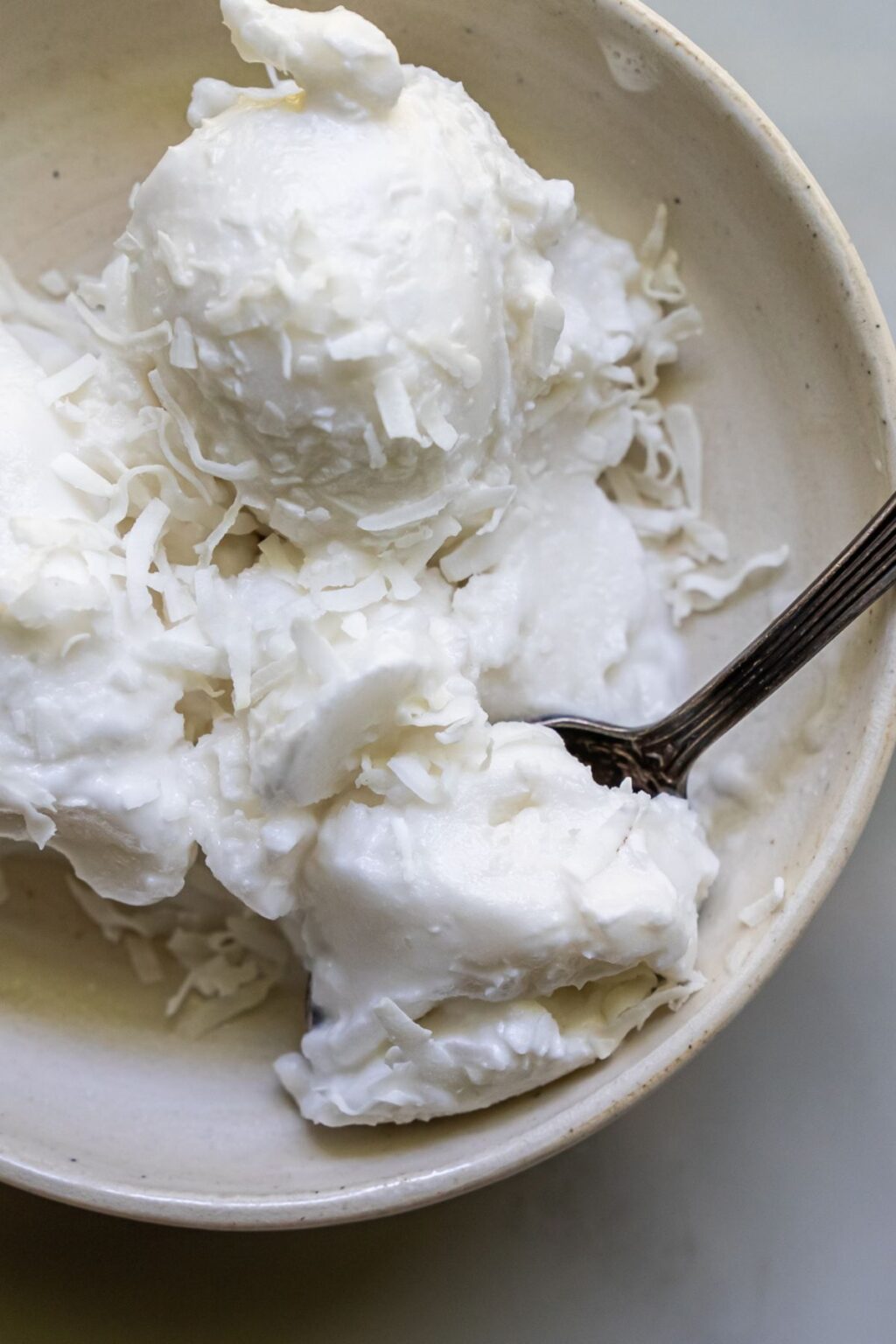 coconut ice cream in a bowl with a spoon.