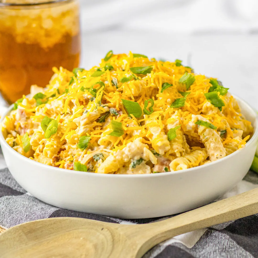 Bowl of chicken bacon ranch pasta with chives and cheese on top.